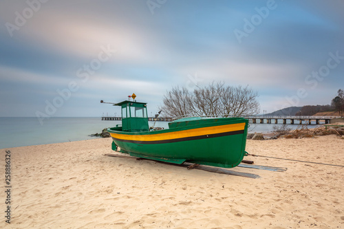Fototapeta Naklejka Na Ścianę i Meble -  Baltic beach in Gdynia Orlowo with fishing boat at dawn, Poland