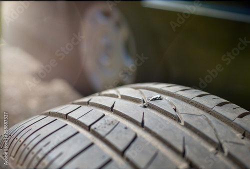 The nail is embedded in car tire close up. Puncture tires. Car wheel repair and balancing