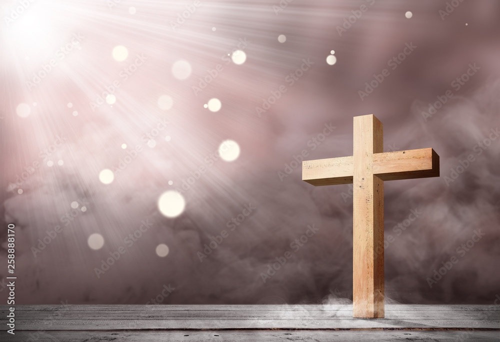 Christian cross on the wooden table with light