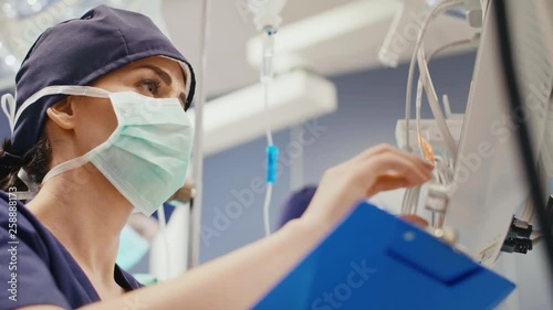 Female anesthesiologist writing down the updates   photo