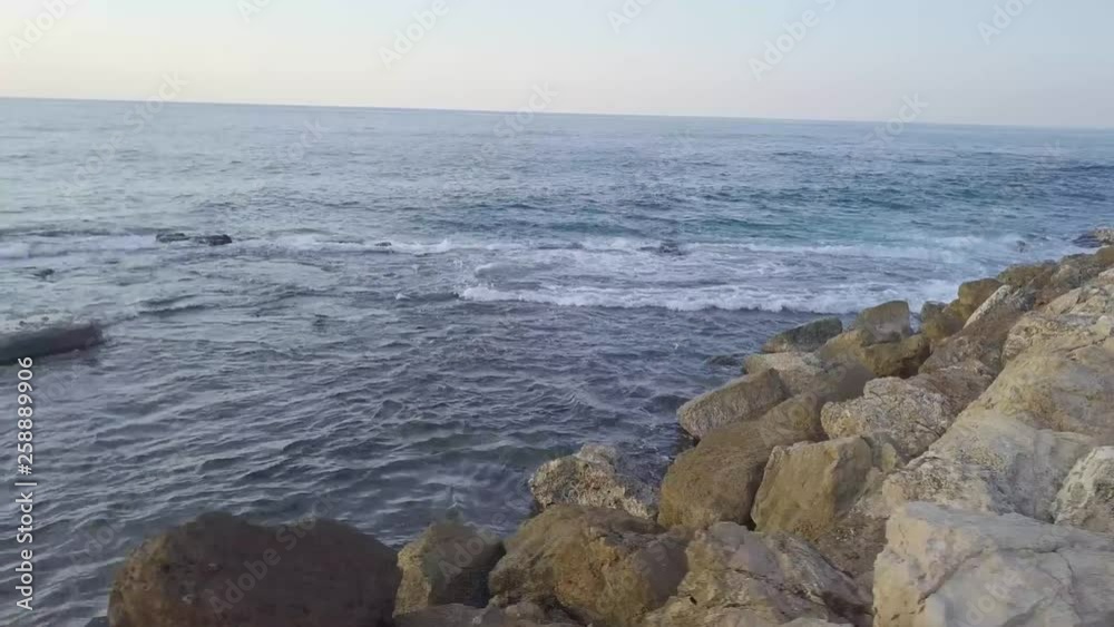 Mesmerizing close up of the rocky breakwater in Jaffa as waves gently lap along the edges