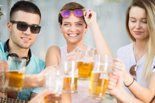 Young group of happy people with a beer outdoors