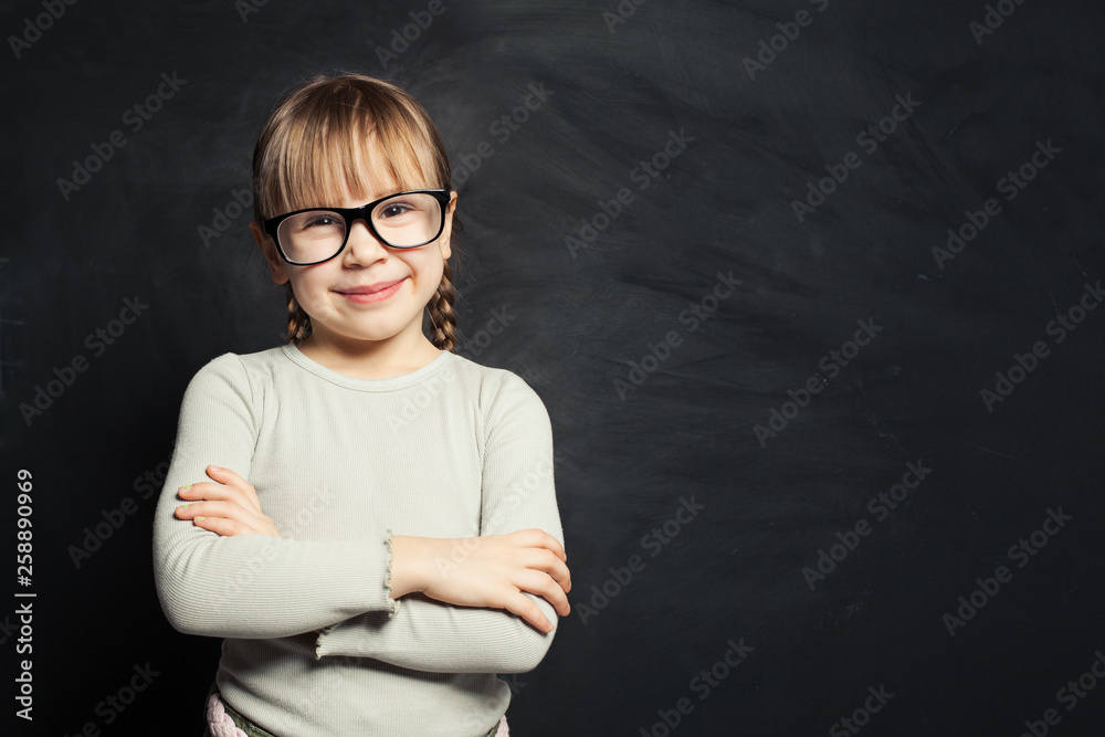 Cute kid portrait. Happy child girl smiling and looking at camera on school classroom background