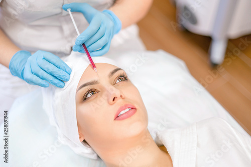 Cosmetology. A cosmetologist performs an injection procedure. Cosmetology clinic.