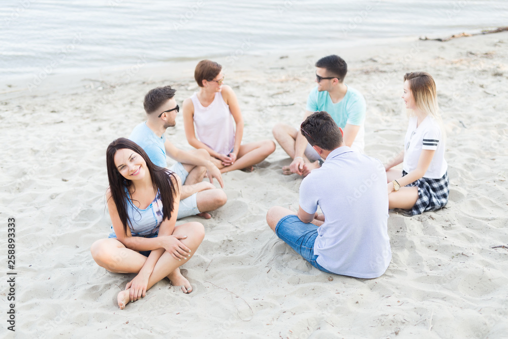 Group of young people sitting at the beach Group of young people sitting at the beach
