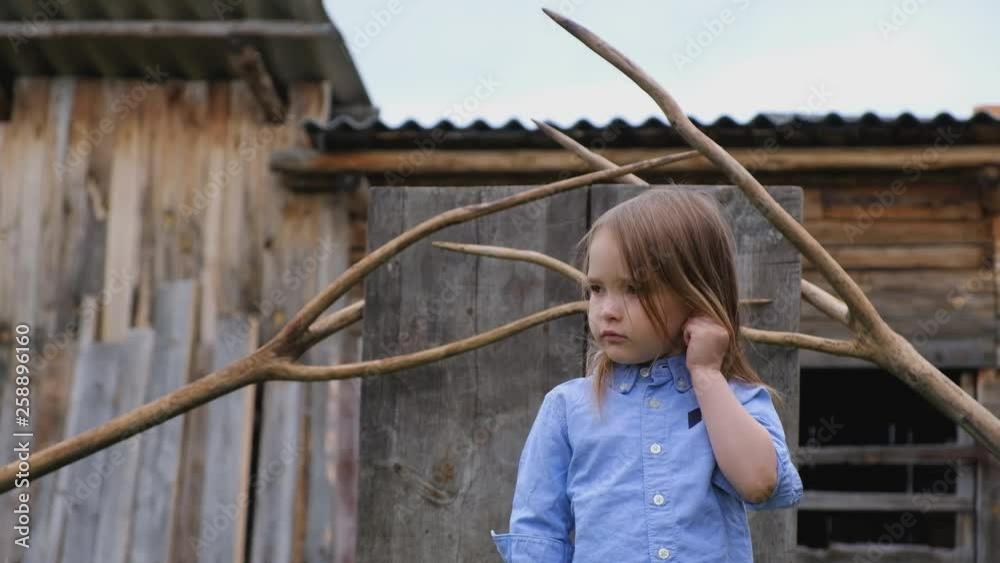 Cute little girl posing on the background of unusual wooden accessories Cute little girl posing on the background of unusual wooden accessories