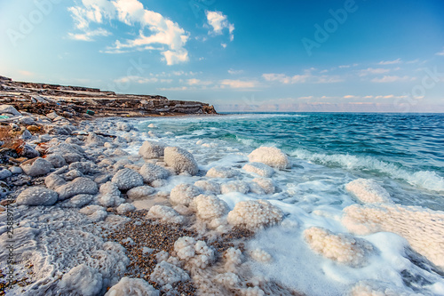 .incredibly beautiful seaside of the dead sea with blue water and white crystals of salt near.selective focus