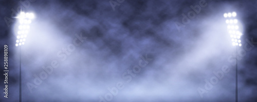 Spotlight Towers on Night Stadium in Smoke.
