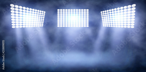 Spotlight Towers on Night Stadium in Smoke.