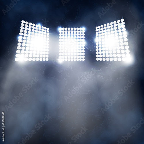 Spotlight Towers on Night Stadium in Smoke.