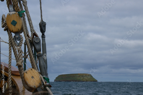 Ropes of an ancient whaler in the foreground and in the background the island where the puffins live. photo