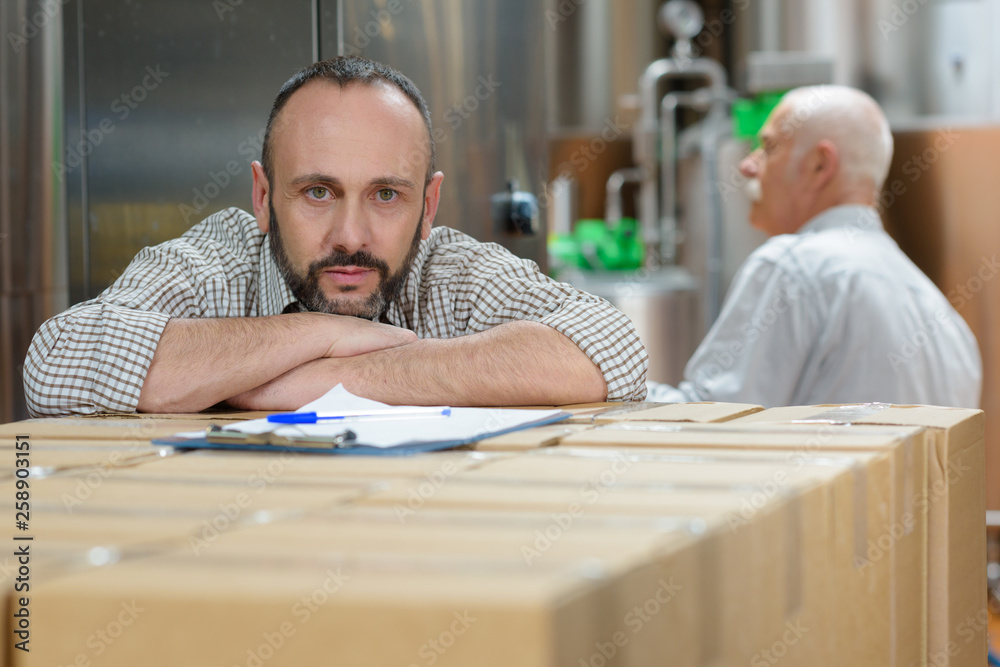 two male colleagues working with boxes two male colleagues working with boxes