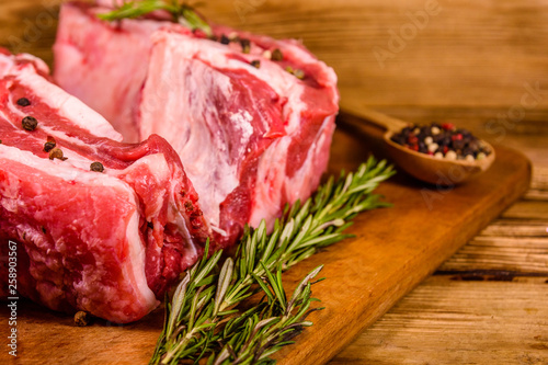 Raw pork ribs with spices and rosemary on a cutting board