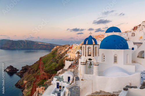 Amazing sunrise view of traditional white houses in Oia village on Santorini island  Greece.