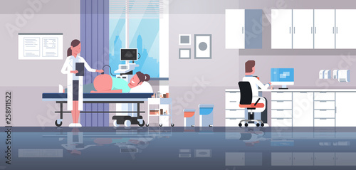 pregnant woman visiting doctor doing ultrasound fetus screening at digital monitor gynecology consultation concept modern hospital interior horizontal flat