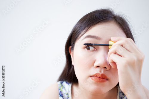 Wallpaper Mural Portrait of beautiful Asian woman using eyelash brushing her eyes close up on white background. Torontodigital.ca