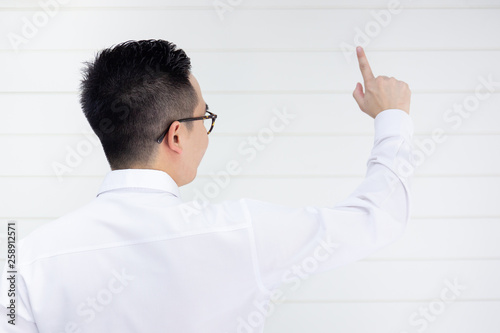 Asian smart and handsom business man in white shirt pointing his finger in the front close up.