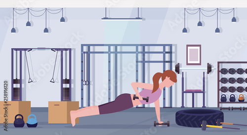 sports woman doing dumbbells plank exercise girl lifting weight working out in gym crossfit training healthy lifestyle concept flat modern health club studio interior horizontal