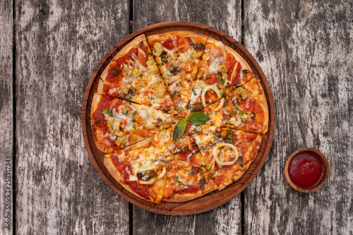 Seafood pizza with sauce on vintage rustic wooden background
