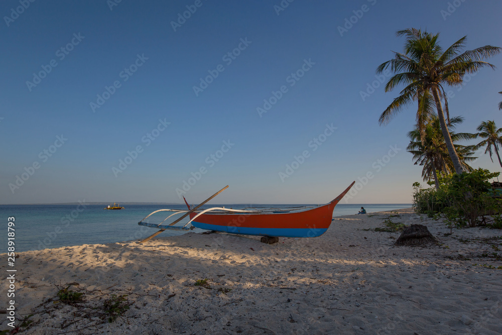 outrigger dive boat at the beach on the white sand, in a tranquil summer sunny day background photo