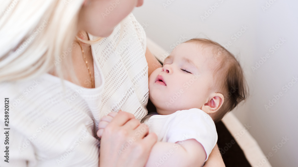 Sleeping baby on woman hands in room. Motherhood. Maternity. Sleeping baby on woman hands in room. Motherhood. Maternity.
