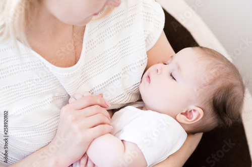 Cute baby sleeping on mother hands close up. Motherhood. Maternity.