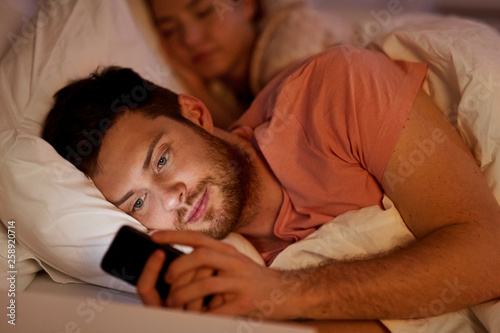 Schilderij op canvas technology, internet addiction and cheat concept - man using smartphone at night