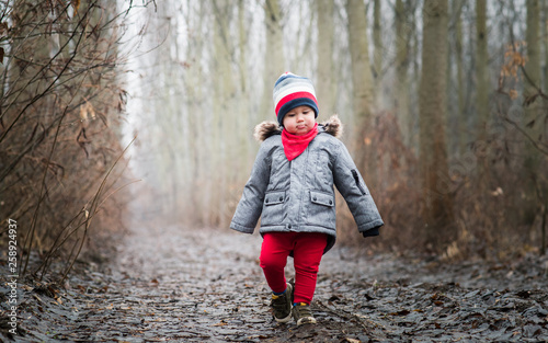 Smiling baby boy walking in the wood