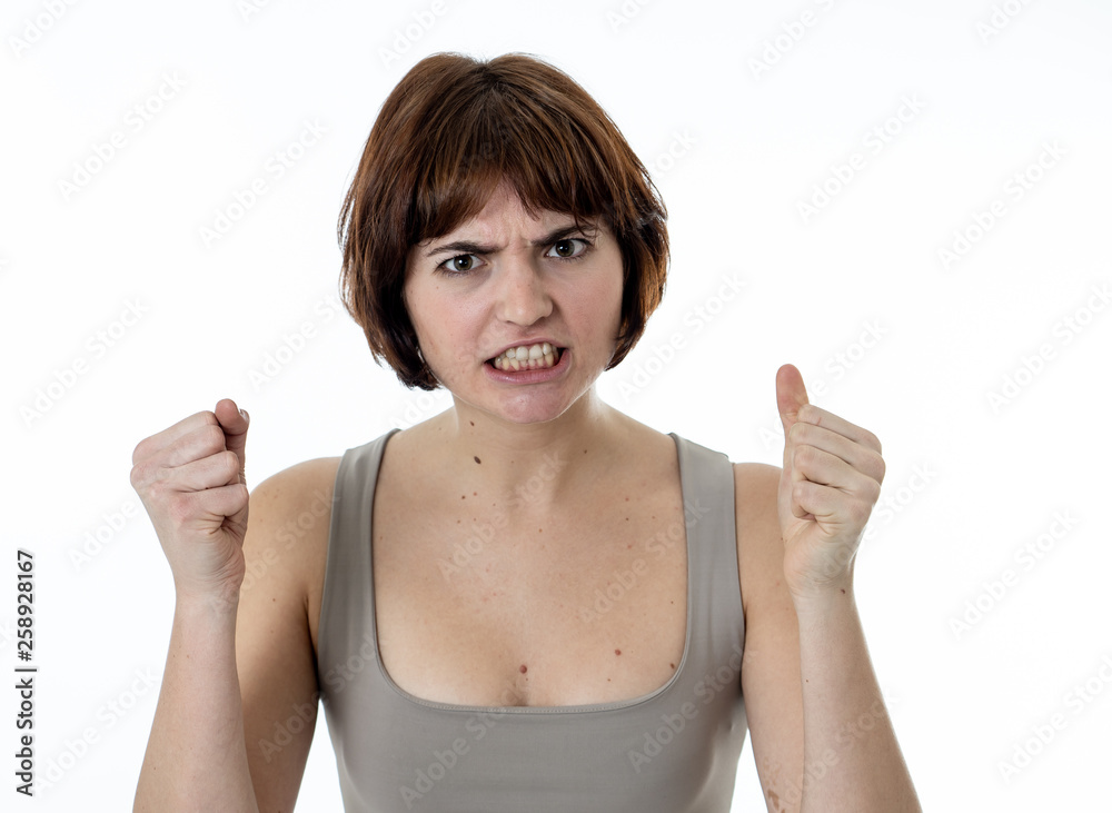 Portrait of a beautiful young woman with angry face looking furious. Human expressions and emotions Portrait of a beautiful young woman with angry face looking furious. Human expressions and emotions