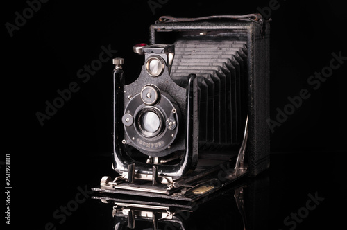 vintage compur camera with reflection on black background