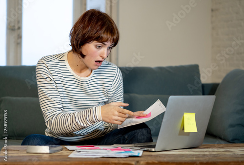 Stressed and overwhelmed young woman trying to manage home finances paying bills feeling desperate