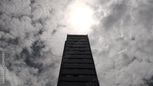 Standing a high rise on a cloudy ,sunny day