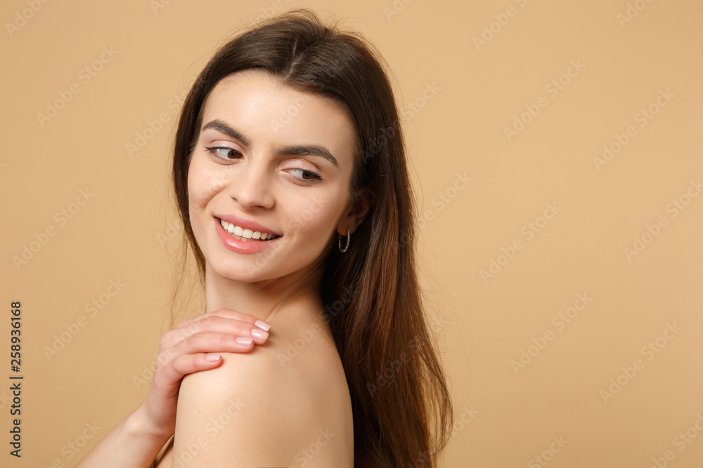 Close up brunette half naked woman 20s with perfect skin, nude make up isolated on beige pastel wall background, studio portrait. Skin care healthcare cosmetic procedures concept. Mock up copy space.