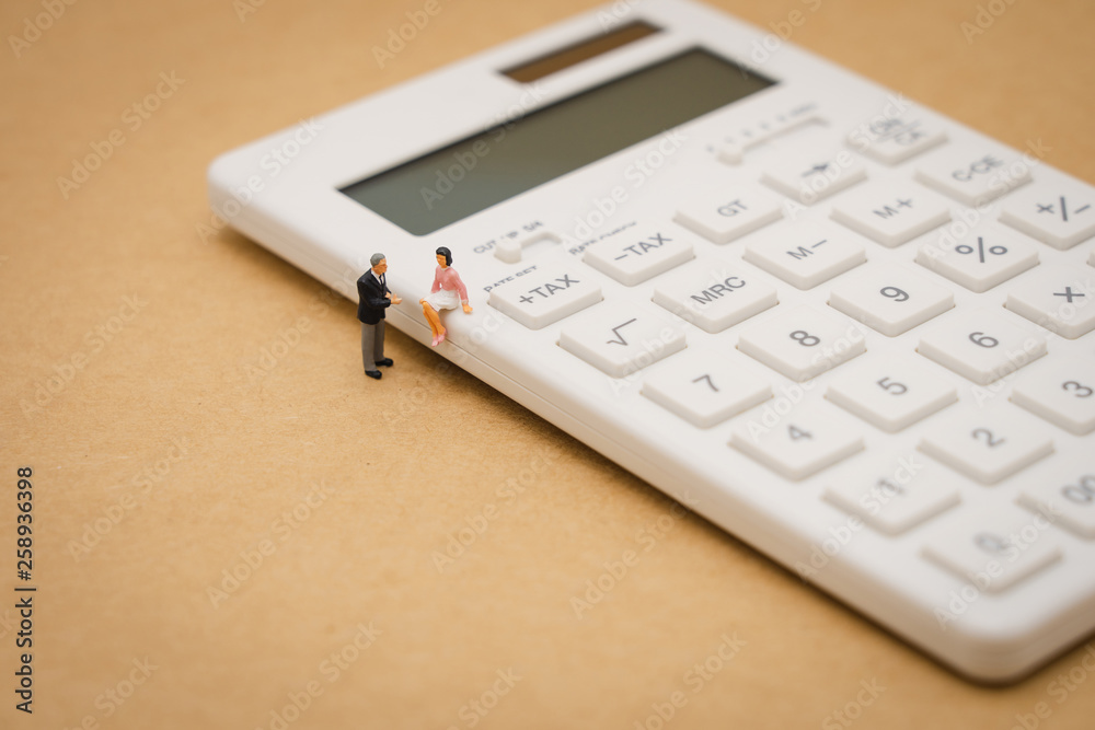 Miniature people Pay queue Annual income (TAX) for the year on calculator. using as background business concept and finance concept with copy space for your text or design. Miniature people Pay queue Annual income (TAX) for the year on calculator. using as background business concept and finance concept with copy space for your text or design.