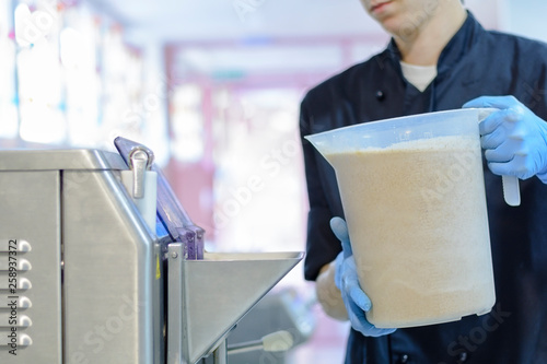 Chef confectioner in uniform producing ice cream with ice cream machine
