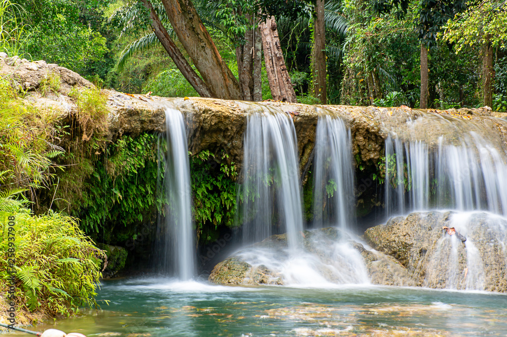 The water flowing over rocks and trees down a waterfall at Kapao waterfall National Park ,Chumphon in Thailand.