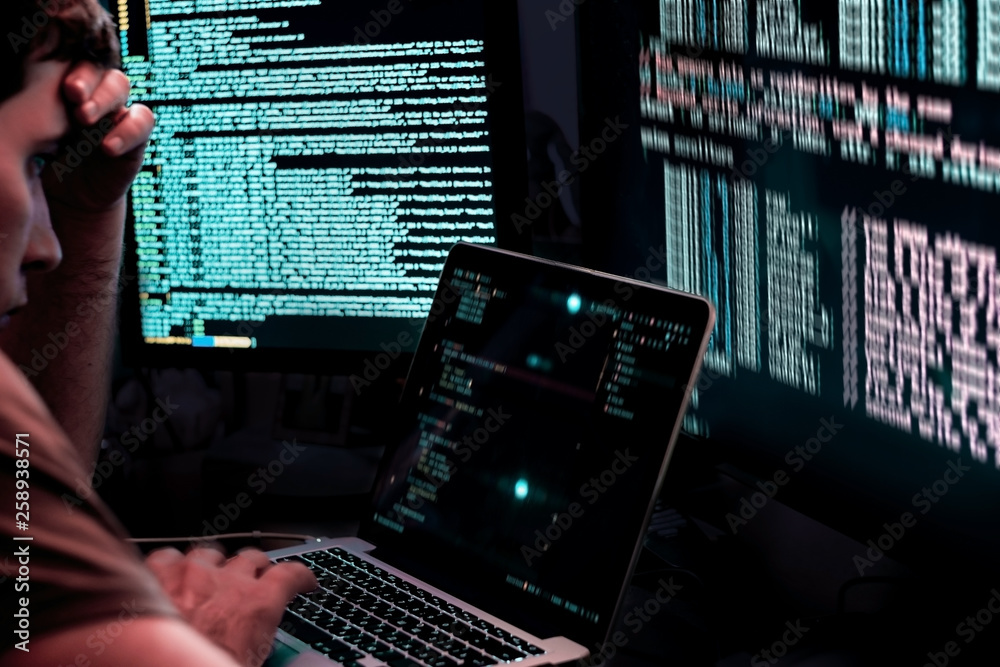 Programmer working on a laptop. The man programs at the computer. It is ...