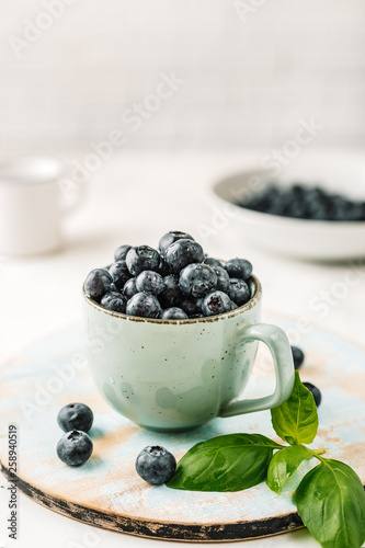 Fresh blueberries in a cup on white background
