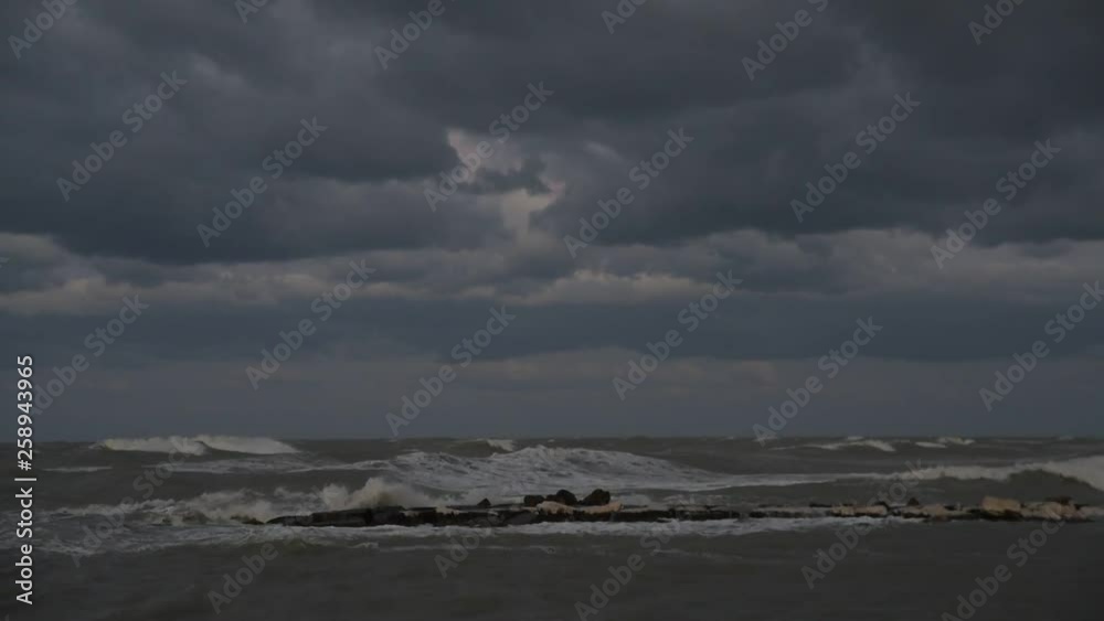 Wind storm in the sea, waves hitting rocks in the rain clouds Wind storm in the sea, waves hitting rocks in the rain clouds