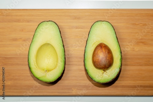 Top down studio shot of avocado cut half on a cutting board