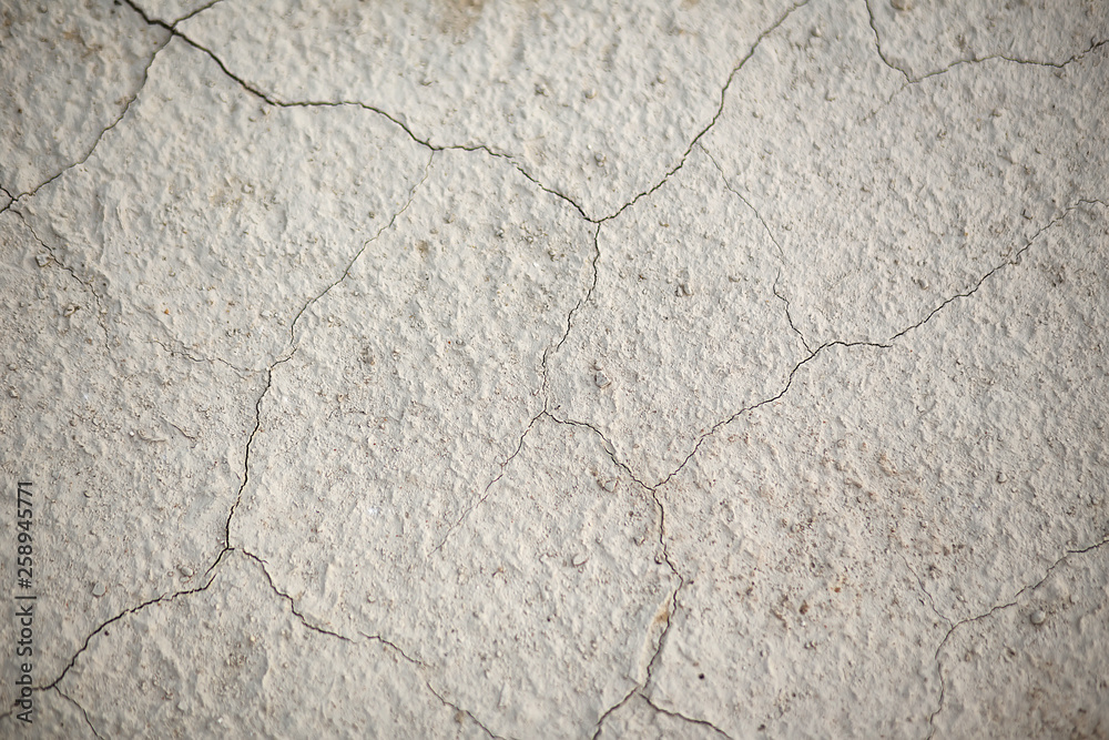 Fototapeta premium the texture of the earth in cracks. A textural, close-up image of sandy desert ground cracked by the heat and lack of water.