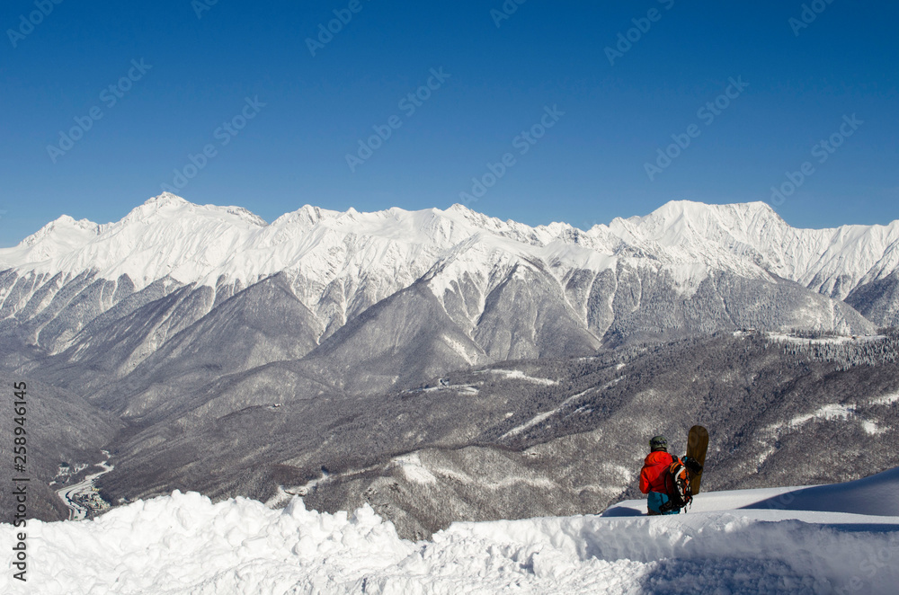 Snowboarder on the top of mountain blue sky background