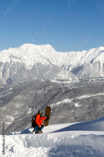 Snowboarder on the top of mountain blue sky background