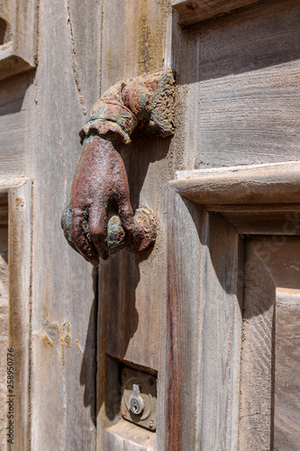 Handshaped Iron Doorknob on a wooden door, Canary Islands, Spain photo