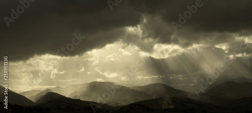 Beautiful landscape at sunset, sunbeams in the dramatic sky