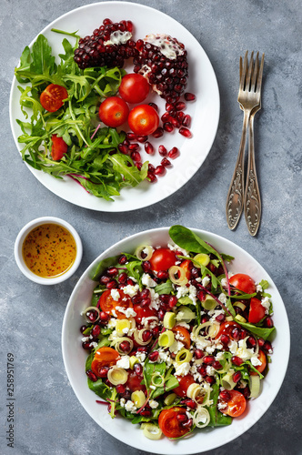 Healthy salad with tomatoes, feta, pomegranate seeds and leek.