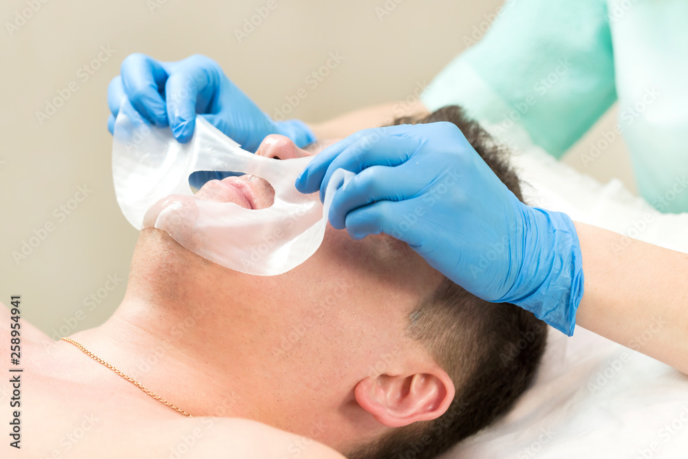 Man in the mask cosmetic procedure in spa salon Man in the mask cosmetic procedure in spa salon
