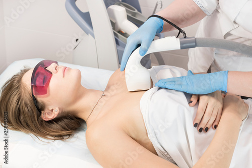 The process of laser depilation of female limbs in the beauty salon.