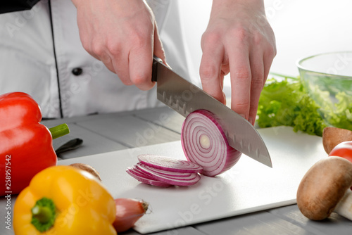 Chef cutting a red onion photo