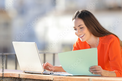 Happy entrepreneur working comparing report online